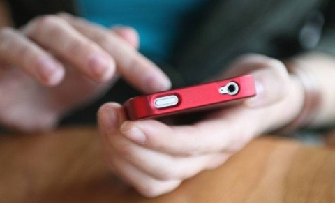 Mãos em smartphone vermelho